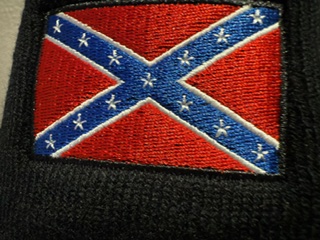 Close-up of embroidered Confederate battle flag patch stitched onto black knit beanie.