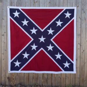 52x52 inch 600d Confederate battle flag hanging on a wooden fence, featuring a red field with a navy blue St. Andrew’s cross, thirteen white stars, white border, and brass grommets.