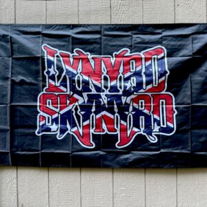 Lynyrd Skynyrd Confederate Flag with bold red, white, and blue logo on black background, displayed outdoors – Southern rock tribute banner.